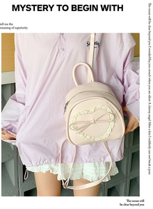 Détail d'un mini sac à dos en similicuir rose avec dentelle cœur et un nœud élégant