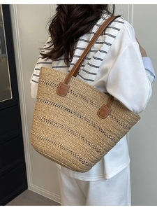 Women's handmade beige woven tote bag with brown leather straps for summer beach travel