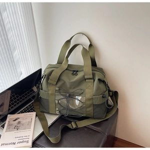 Détail du sac de sport vert olive avec cordons élastiques et poches filet sur bureau