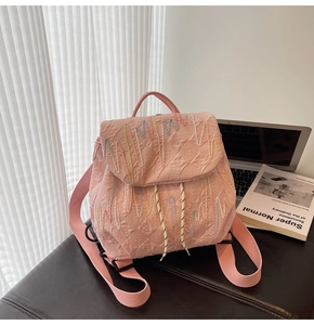 Detail of pink backpack with embossed E texture and colorful wavy stitching on the front