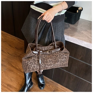 Dettaglio della borsa shopper vintage leopardata con manici in pelle marrone e fibbia
