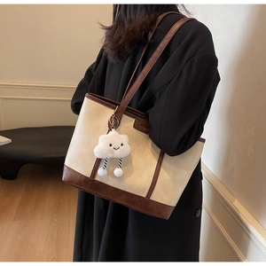 Retro cream tote bag with brown leather trim and cute cloud charm shown in detail