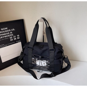 Détail du sac de voyage noir avec poche frontale transparente et cordon élastique
