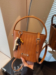 Brown woven texture bucket bag with beaded charm and adjustable strap for women