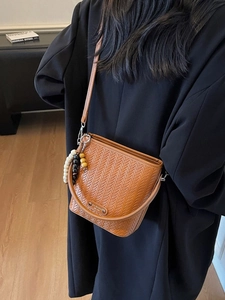 Brown woven texture crossbody bucket bag with beaded charm and elegant top handle