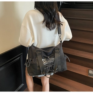 Détail du sac de voyage en toile noire avec poche PVC transparente et cordons croisés