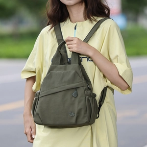 Front view of an olive green lightweight nylon multifunctional backpack on a female model