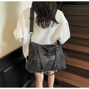 Détail d'un grand sac de voyage noir avec cordons élastiques et bandoulière réglable