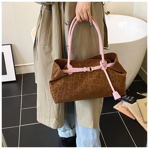 Détail du cabas léopard avec anses roses porté avec un trench-coat beige élégant