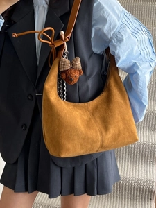 Vintage brown suede crescent hobo bag with a cute bear charm shown on a model