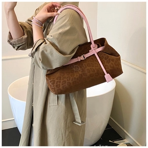 Détail du sac cabas léopard avec bandoulière rose vif et finitions métalliques