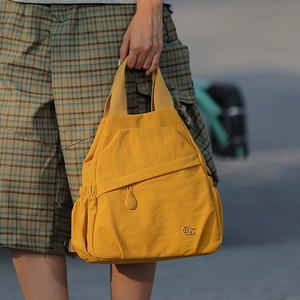 Detail of bright yellow nylon multi-functional bag with mS logo and drawstring side pocket