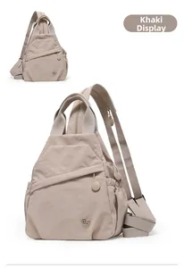 Detail view of khaki nylon multifunctional backpack with zippers and side elastic pocket