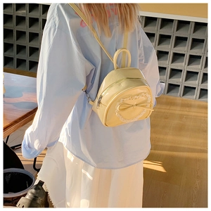 Détail du mini sac à dos jaune avec cœur en dentelle et nœud dans un café cosy