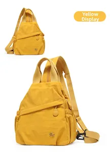 Close-up of bright yellow nylon mini backpack featuring metal logo and side pocket details