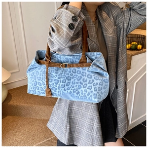 Détail d'un sac fourre-tout à imprimé léopard bleu avec lanières en daim marron et boucle