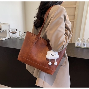 Brown vintage leather tote bag detail with cute white plush cloud charm for women
