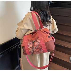 Vue détaillée d'un grand sac de voyage terre cuite sur un escalier en bois intérieur