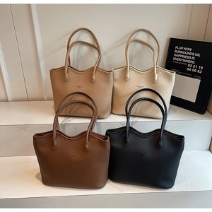 Détail de grands sacs fourre-tout en cuir en coloris camel, blanc, marron et noir