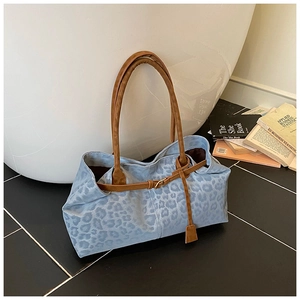 Détail du sac cabas à imprimé léopard bleu clair avec une sangle décorative à boucle marron