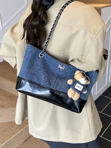 Chic denim and black leather patchwork tote bag with chain strap and bear charm
