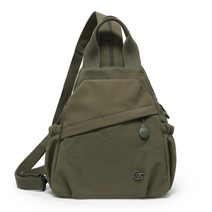 Detailed view of an olive green nylon sling bag with zippered pockets and wide strap