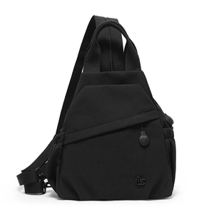 Detail of black nylon sling bag featuring triangle silhouette and adjustable strap