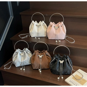 Vue détaillée de sacs seaux colorés avec poignées métalliques et breloques papillon