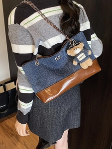 Denim and brown leather patchwork tote bag with chain strap and teddy bear charm