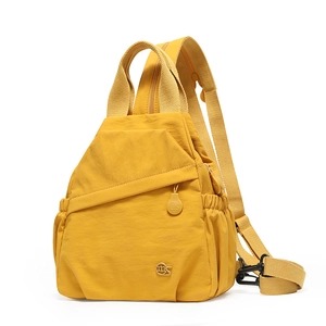 Detail of a ginger yellow lightweight nylon backpack with a metallic logo and side pocket