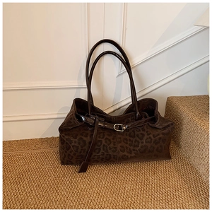 Détail de la texture en daim à imprimé léopard et boucle métallique élégante sur le sac cabas