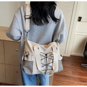 Détail du grand sac de voyage beige avec maille respirante et poche latérale à cordon