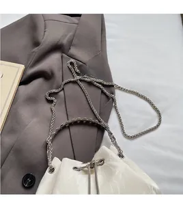 Détail du sac seau blanc texture marbre avec chaîne argentée et poignée en métal