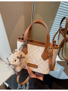 Fashionable checkerboard tote bag with plush bunny charm and adjustable shoulder strap