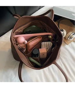 Vue de dessus de l'intérieur du grand sac fourre-tout marron avec ordinateur et accessoires
