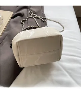 Détail du sac seau blanc cassé avec texture marbre et bandoulière chaîne argentée
