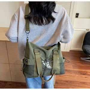 Detail view of large nylon crossbody bag with PVC pocket and adjustable drawstring