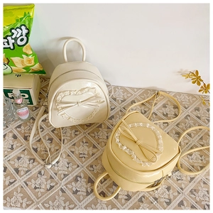 Détails de dentelle en cœur et nœud sur les sacs à dos en cuir verni brillant