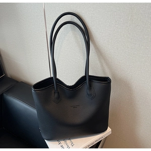 Gros plan du sac cabas noir en cuir grainé montrant la texture et les fines bandoulières