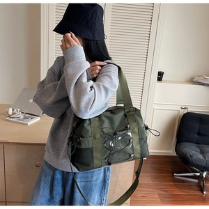 Détail du sac de voyage vert armée avec poche transparente et cordes sur le bureau