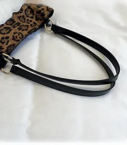 Detail of the leopard print tote bag with black long leather straps and gold metal rings