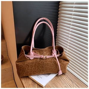 Détail du cabas à imprimé léopard avec bordures en cuir rose et boucles métalliques