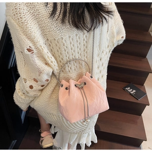 Détail d'un sac seau rose avec cordon papillon et accents de perles décoratives