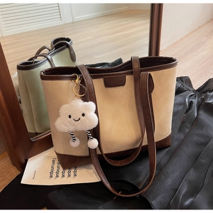 Detailed macro view of the vintage contrast tote bag with a soft cloud plush pendant