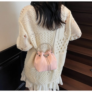 Détail du sac seau plissé rose avec fermoir papillon, chaîne et poignée en métal
