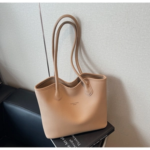 Détail du sac cabas abricot clair avec texture litchi et texte mode sur le devant