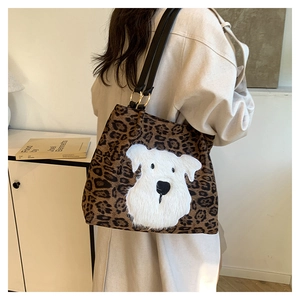 Macro detail of leopard print tote bag featuring plush schnauzer patch and gold hardware