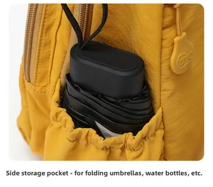 Détail de la poche latérale d'un sac à dos en nylon jaune avec un parapluie noir
