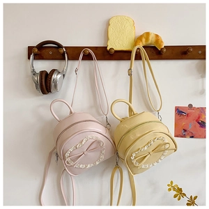 Détails de mini sacs à dos en dentelle rose et jaune avec nœuds sur crochets en bois