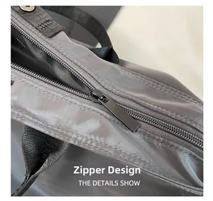 Close-up of durable black metal zipper design on grey waterproof nylon travel tote bag